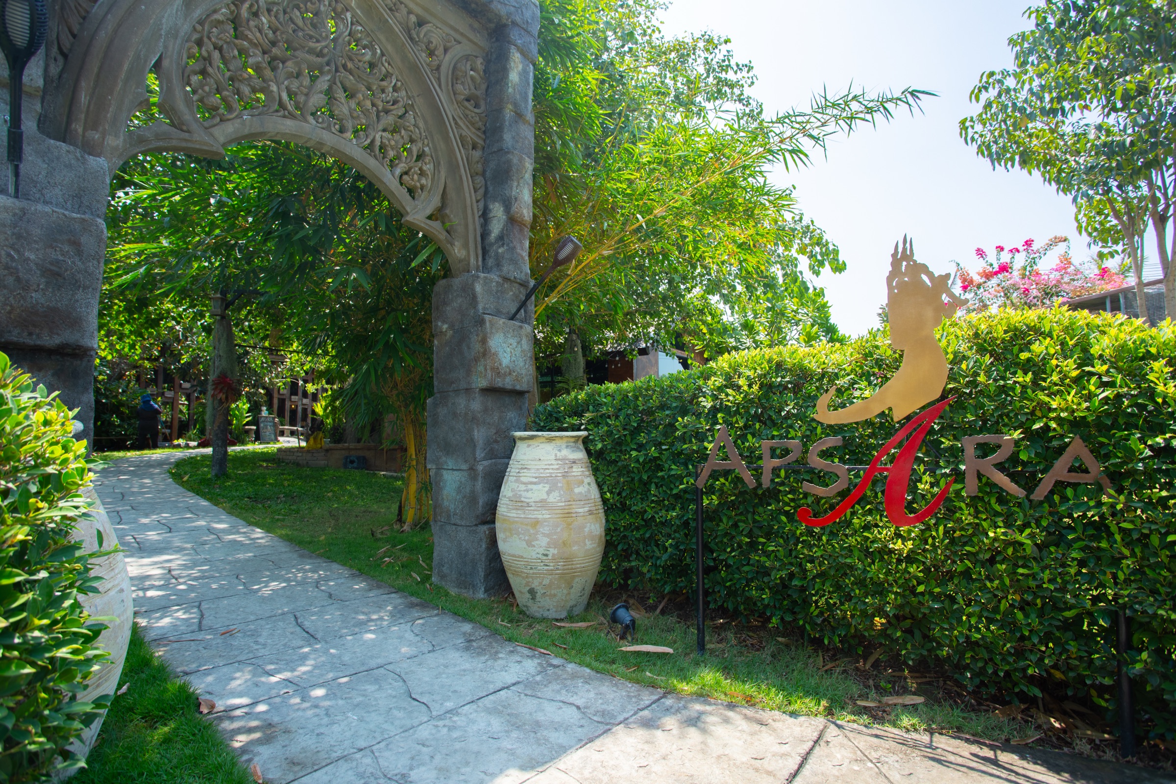 Carved entrance arch and garden path at Apsara