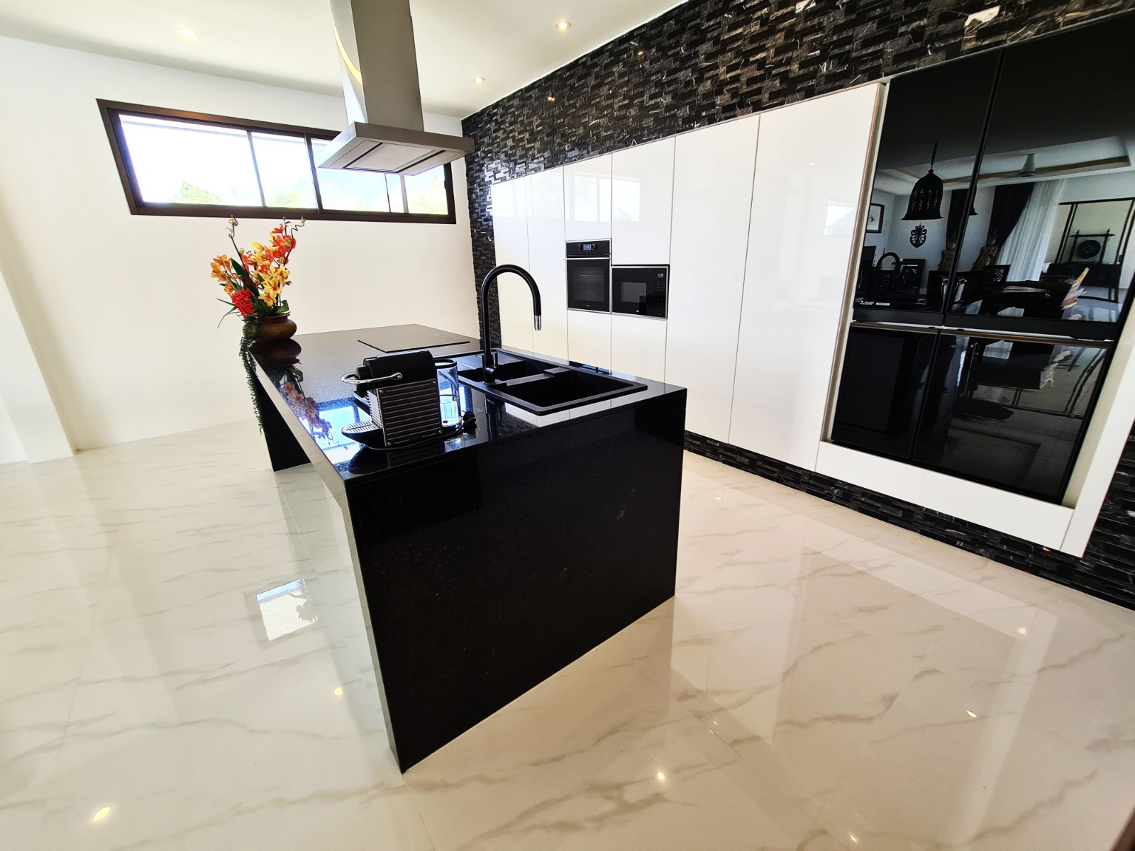 Modern kitchen with black stone island and white cabinetry